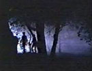 [Two small figures travel silently through the dark misty woods.]